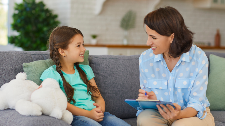 Photo of an adult meeting with a smiling child with a teddy bear
